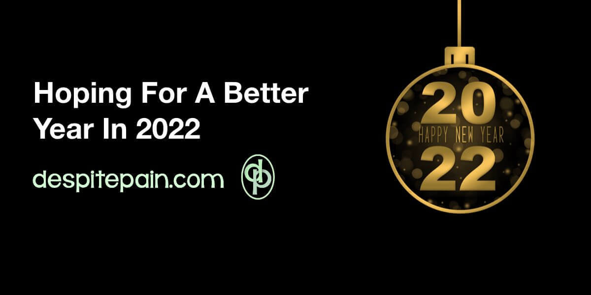 Hope for a better year in 2022. The image has a black background with a decorative ball hanging with 2022 in gold and happy new year written in the middle.